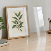 Illustration of a clear acrylic sheet beside framed artwork on a worktable